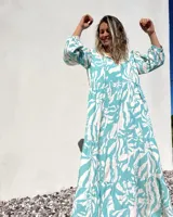 Vestido largo de corte amplio, con estampado abstracto en tonos verde agua y crudo. Tiene escote en V con lazos y mangas largas abullonadas.