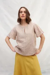 Blusa blanca de lino con escote en V y mangas cortas amplias.