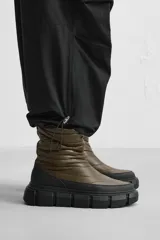 Bota corta color verde militar con diseño acolchado, tirador trasero y suela track negra.