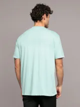 Remera celeste de algodón con cuello redondo y logo de Calvin Klein estampado en el pecho dentro de un recuadro blanco.