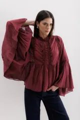 Camisa color marrón con cuello mao, mangas largas abullonadas y detalle de volados en el frente.