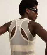 Musculosa deportiva de tule color crudo, con escote redondo y espalda nadadora. Presenta encaje en los laterales.