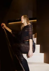 Conjunto negro de pantalón palazzo de tiro alto con cintura elastizada y poncho corto con mangas amplias.