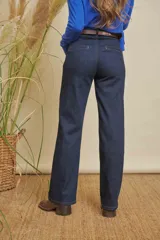 Jeans de mujer color azul oscuro, de pierna recta, con bolsillos ojal en la parte trasera. Incluye un cinturón bordado con diseño geométrico en tonos tierra.