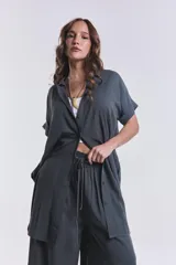 Camisola verde grisáceo de tencel con cuello camisero, mangas cortas con dobladillo y cierre frontal con botones.