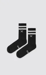 Medias negras de caña media con dos rayas blancas en la parte superior, logo de tijeras bordado en blanco en el tobillo y letras "OX" en el empeine.