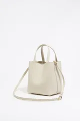 Bolso tote pequeño de piel reconstituida color gris claro, con estructura rígida, doble asa corta, correa extraíble, cierre con botón de presión, logo metálico BIMBA Y LOLA, acabados metálicos, bolsillo interior con cierre de cremallera e interior con logo grabado.