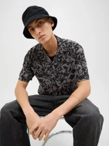 Camisa de manga corta con estampado floral, cuello resort y cierre con botones.