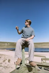 Pantalón de jean celeste de corte amplio, con tiro alto, cinco bolsillos y cierre con botones.