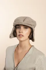 Boina con visera y orejeras de lana color beige con diseño de espiga.
