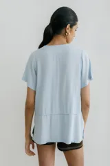 Remera blanca con corte horizontal y parte inferior negra. Cuello en V y mangas cortas.