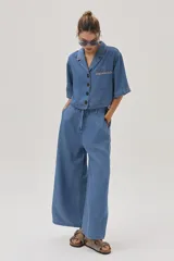 Pantalón de jean celeste de corte ancho, con cintura alta y lazo ajustable.