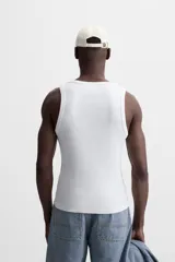 Musculosa negra ajustada al cuerpo, con cuello redondo y sisas amplias.