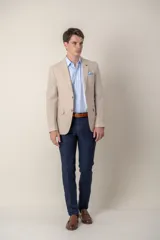 Saco de lino color beige, corte slim fit, con solapa de muesca, cierre de dos botones, bolsillo en el pecho y dos bolsillos delanteros con solapa. Medio forro.