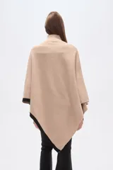 Poncho beige de poliéster con cuello alto y terminaciones en negro.