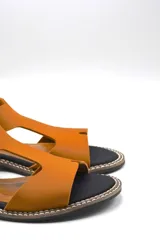 Sandalia plana color gris con tiras anchas de neopreno y detalles en cuero.