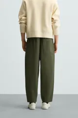 Pantalón verde militar de corte carrot fit, confeccionado en tejido de algodón. Cuenta con cintura elástica ajustable con cordón, bolsillos frontales y un bolsillo trasero de plastrón.