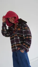 Buzo canguro oversize con capucha y cuello alto, confeccionado con paños de lana estampados.