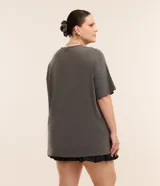 Remera gris de algodón con cuello redondo y manga corta. Presenta un estampado central de un lazo negro.