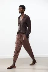 Pantalón jogger marrón de tiro alto con cintura elástica ajustable con cordones, bolsillos delanteros y puños elásticos en los tobillos.