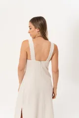 Vestido largo color beige de lino imperial, con escote en V, espalda con tirantes anchos y bordados en la parte superior. Tiene tajos a ambos lados.