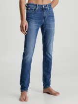 Jeans de denim elástico azul con efecto lavado, corte skinny, tiro bajo, cinco bolsillos y cierre con cremallera.
