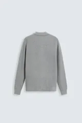 Polo marrón de corte relaxed fit, tejido en punto de algodón. Tiene cuello solapa con cierre frontal de botonadura, manga larga y acabados en rib.
