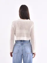 Sweater tejido de punto calado color blanco, de corte crop y mangas largas acampanadas.