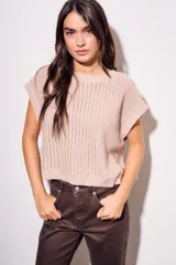 Chaleco de punto color beige con lurex, de corte recto y mangas cortas. Tejido calado con pequeños agujeros.