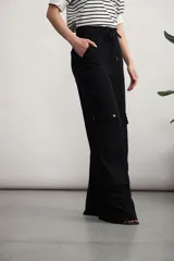 Pantalón cargo color verde oliva, de corte ancho, con bolsillos laterales con solapa y cintura con cordón ajustable.