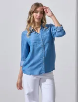 Camisa celeste de lyocell, con cuello a la base, escote en V y abertura central con botones. Tiene bolsillos aplicados en la parte delantera y mangas 3/4 regulables con presilla y botón.