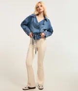 Campera corta tipo trench coat confeccionada en tejido denim de algodón. Presenta cuello con solapa, escote en V, manga larga, cierre frontal con botones y lazo en la cintura.