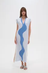 Vestido largo de viscosa con estampado abstracto en tonos beige, amarillo y negro. Tiene cuello en V, mangas cortas, corte holgado y tajo lateral.