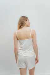 Pijama de algodón compuesto por musculosa con escote recto y detalle de puntilla elastizada, y short con elástico y lazo en la cintura.