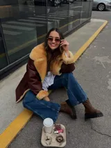 Campera de cuero color marrón con cuello y puños de piel sintética color beige.