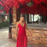 Vestido largo de microtul rojo, con breteles finos y escote en V. Tiene doble tela en la parte superior.