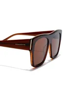 Lentes de sol unisex marca Hawkers, modelo Paula x Hawkers - Doumu Brown. Montura rectangular color marrón con detalles dorados y lentes marrones.