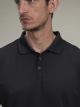 Polo de piqué azul marino, de corte clásico, con cuello abotonado y mangas cortas.