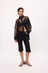 Pantalón capri negro con terminación en picos y costuras en color ladrillo.