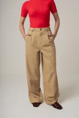 Pantalón de vestir color beige, de corte palazzo, con bolsillos laterales y traseros.