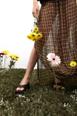 Falda larga marrón con diseño de cuadros amarillos, corte recto y tajo lateral.