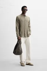 Camisa celeste de lino, de corte recto, manga larga y cuello clásico.