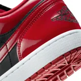 Zapatilla deportiva de corte bajo, color negro y rojo brillante (charol), con suela blanca y cordones negros. Presenta el logo Swoosh en negro y el logo de Air Jordan en el talón.