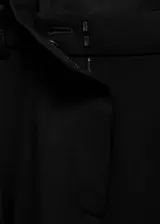 Pantalón de vestir negro de corte recto, con tiro medio, trabillas para cinturón, pinzas frontales y bolsillos laterales.