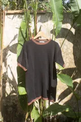 Remera negra de tejido artesanal en hilado 70% algodón y 30% acrílico, con cuello y mangas con ribete marrón.