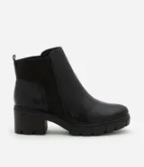 Bota Chelsea color negro, confeccionada en poliuretano, con detalle elástico acanalado en los laterales y suela track.