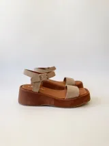 Sandalias con plataforma color beige, con tira ancha sobre los dedos y tira con hebilla al tobillo.