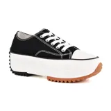 Zapatillas deportivas urbanas negras con puntera blanca y suela gruesa con detalles marrones.