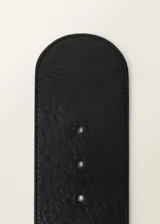 Cinturón ancho de cuero negro con hebilla forrada y cierre oculto.