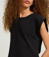 Blusa sin mangas, color blanco, confeccionada en tejido rib de algodón, con cuello redondo y hombreras marcadas.